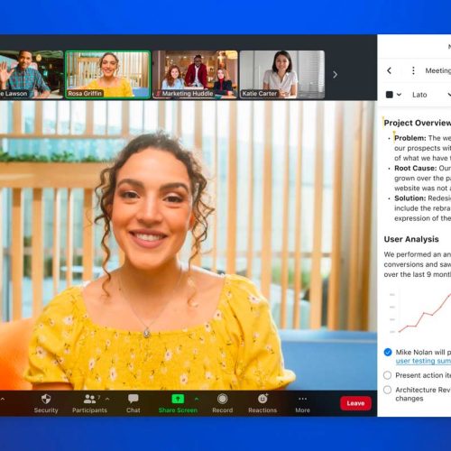 A woman smiling while engaged in a video call with her colleagues and managing a project