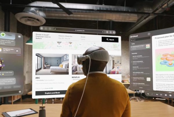 A person wearing a virtual reality headset interacts with multiple floating, computer-generated screens in a modern, industrial-style office space.