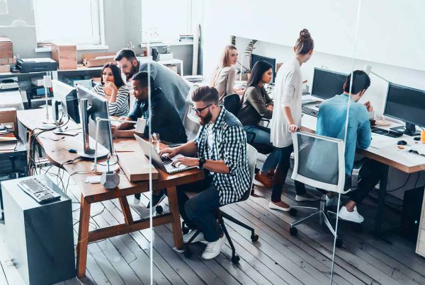 A diverse team collaborating in a modern office environment, engaged in professional tasks and discussions.